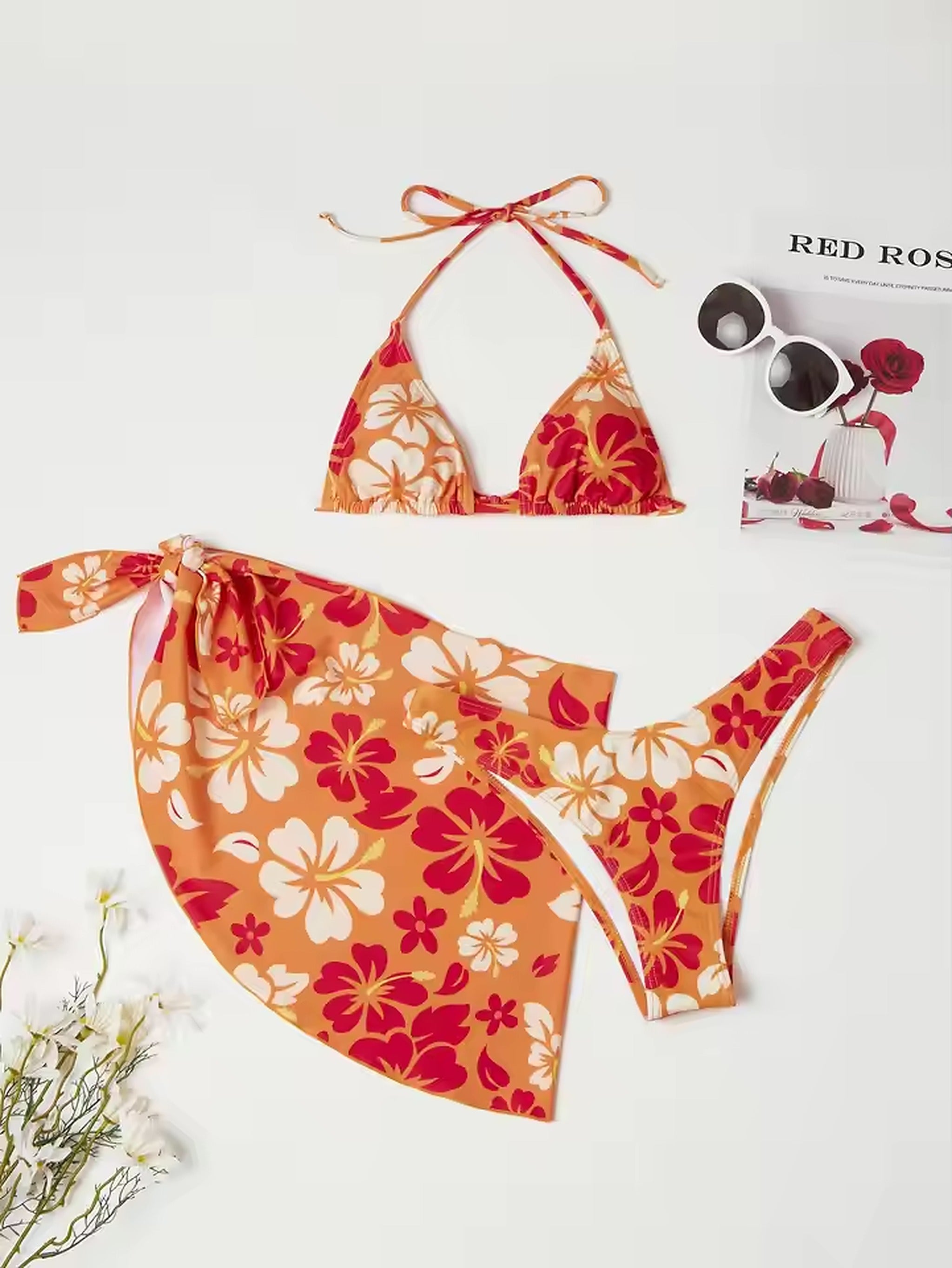 Sunset Mana bikini with vibrant red and orange floral print, featuring halter top and matching bottoms with wrap skirt