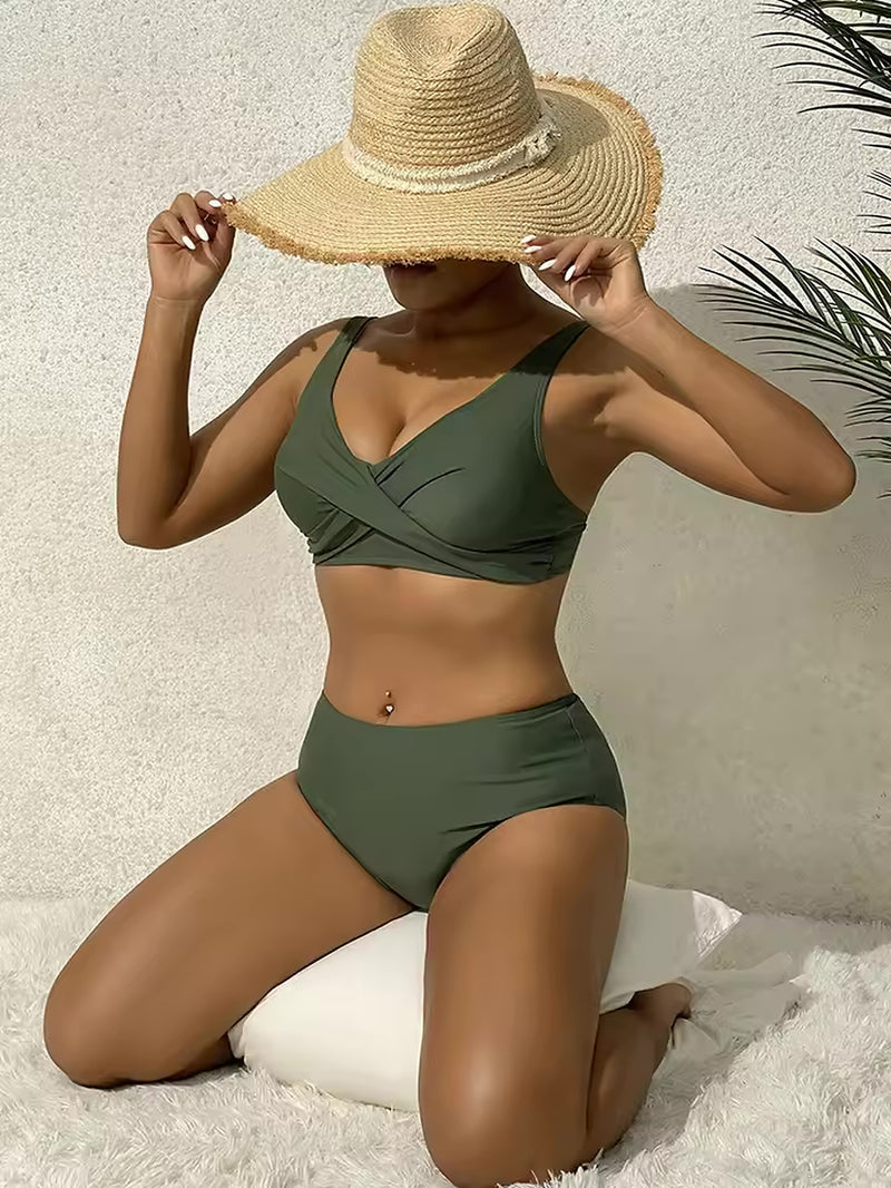 Olive green two-piece bikini with wrap-front top and high-waisted bottoms worn with straw hat.