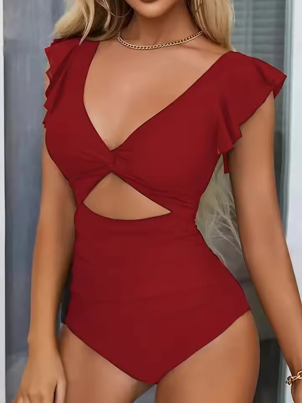 Red one-piece swimsuit with ruffled V-neckline, cutout back detail, and cap sleeves