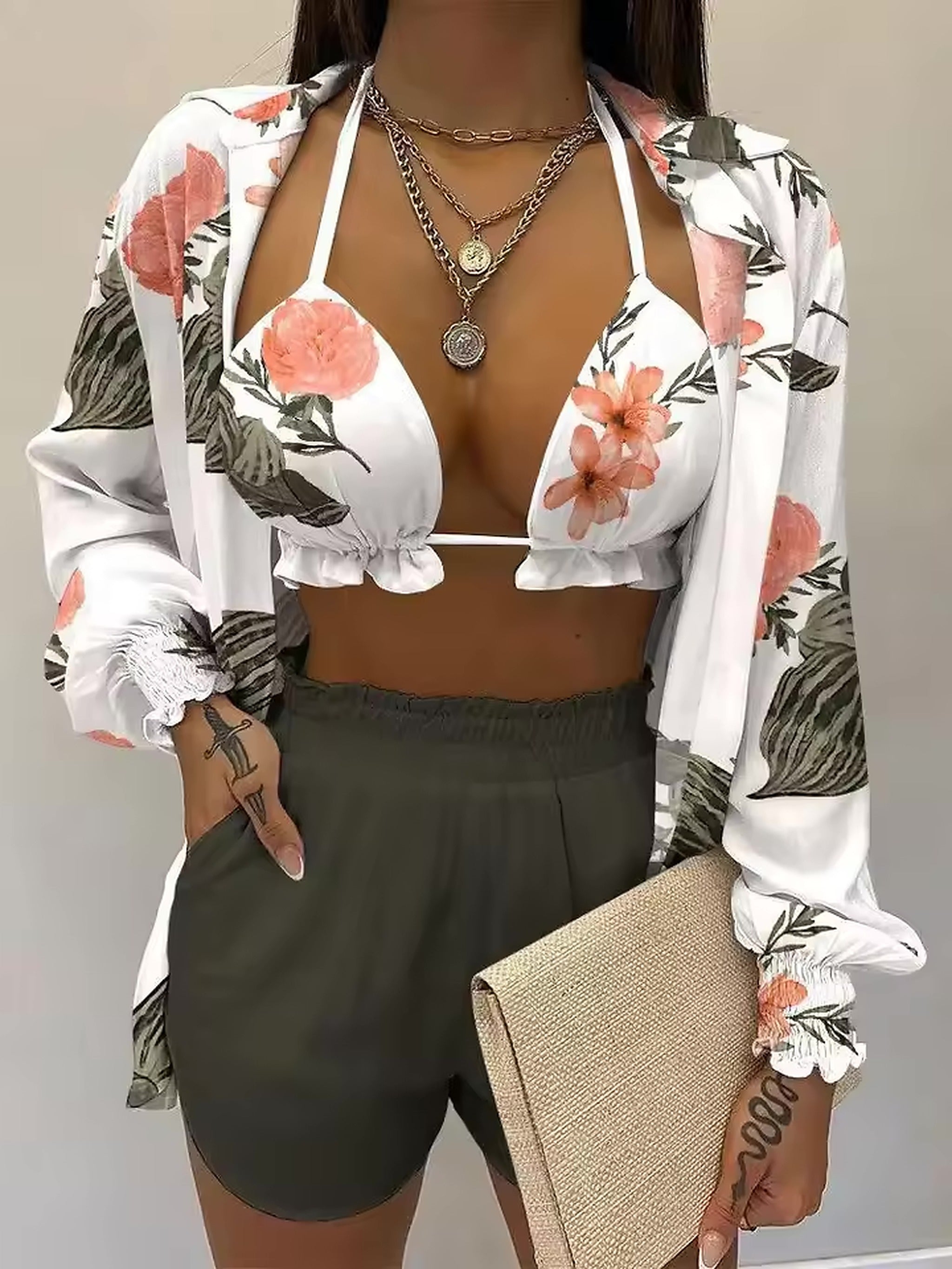 White floral bikini top with coral and green botanical print, paired with olive shorts and matching shirt jacket