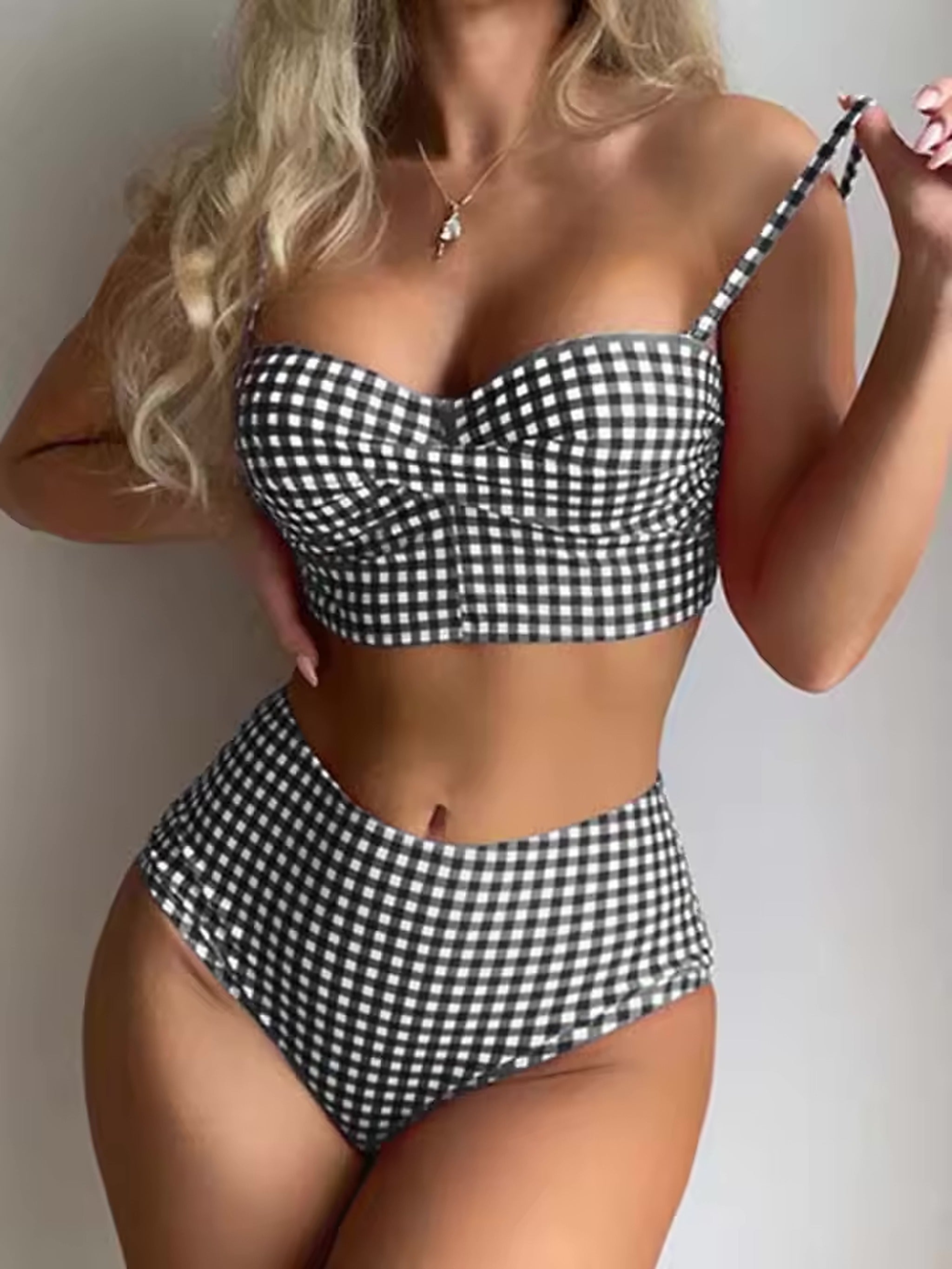 Black and white gingham bikini with sweetheart neckline and high-waisted bottoms on model wearing silver pendant necklace.