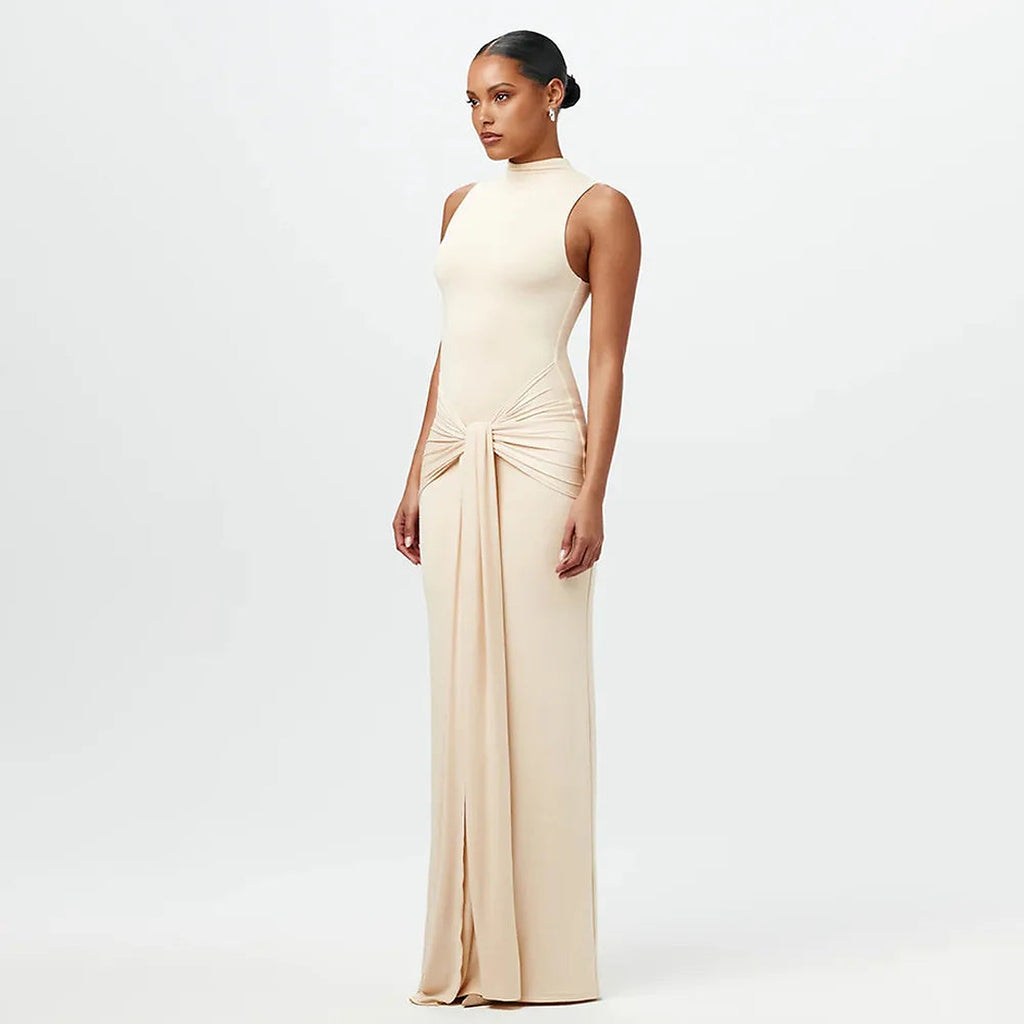 Woman wearing cream sleeveless Maia bikini with side tie detail and high-waisted bottom in minimalist Scandinavian style
