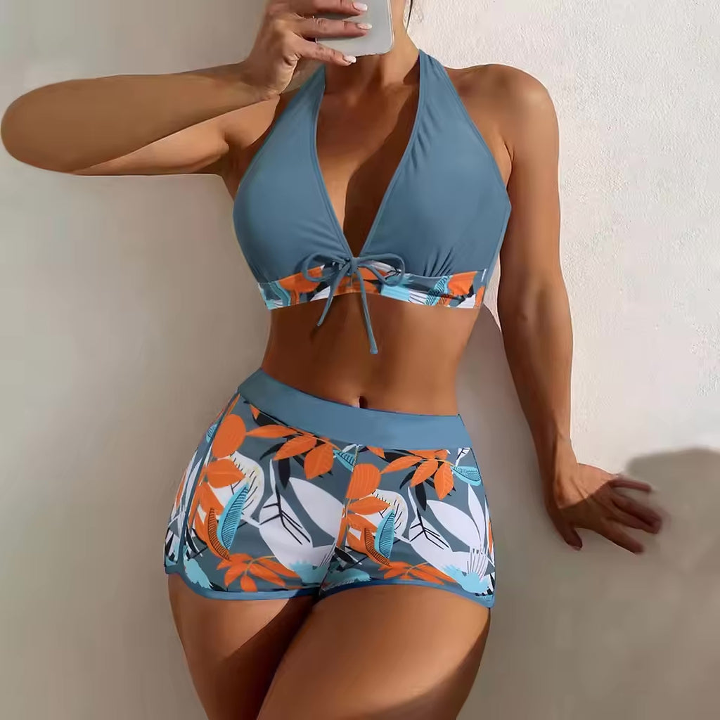 Blue halter bikini top with orange botanical print and matching patterned swim shorts