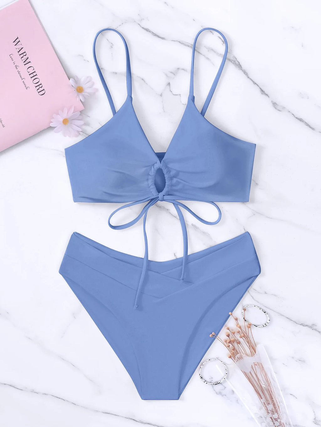 Periwinkle blue bikini with tie-front top and high-waisted bottom on marble background