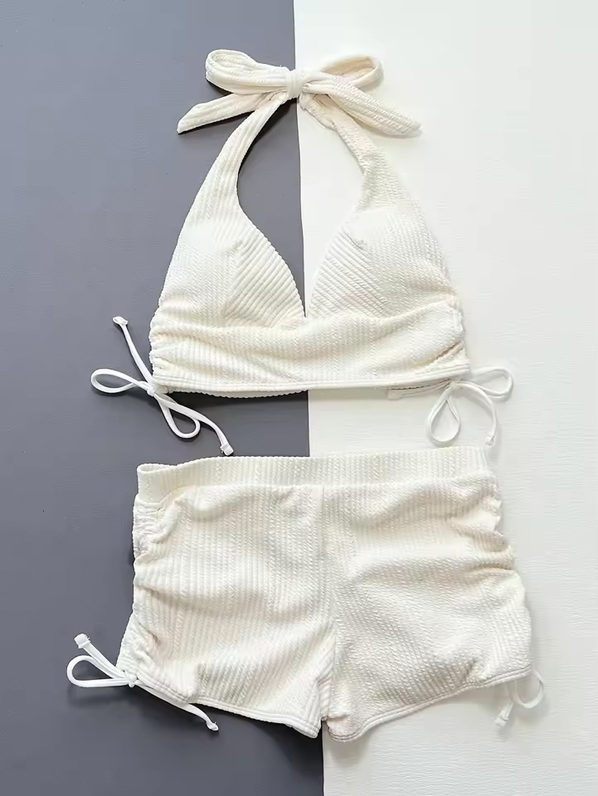 White ribbed halter bikini with tie-side bottoms and adjustable straps on neutral background