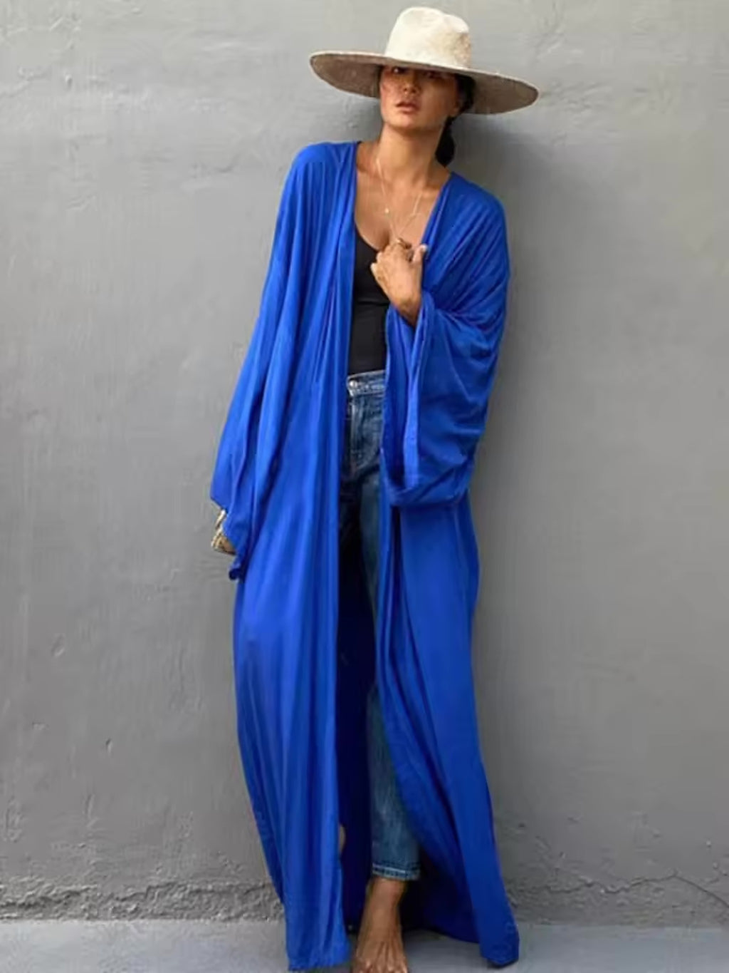 Woman wearing bright blue Luna Mare cover-up over black swimsuit with wide-brimmed hat