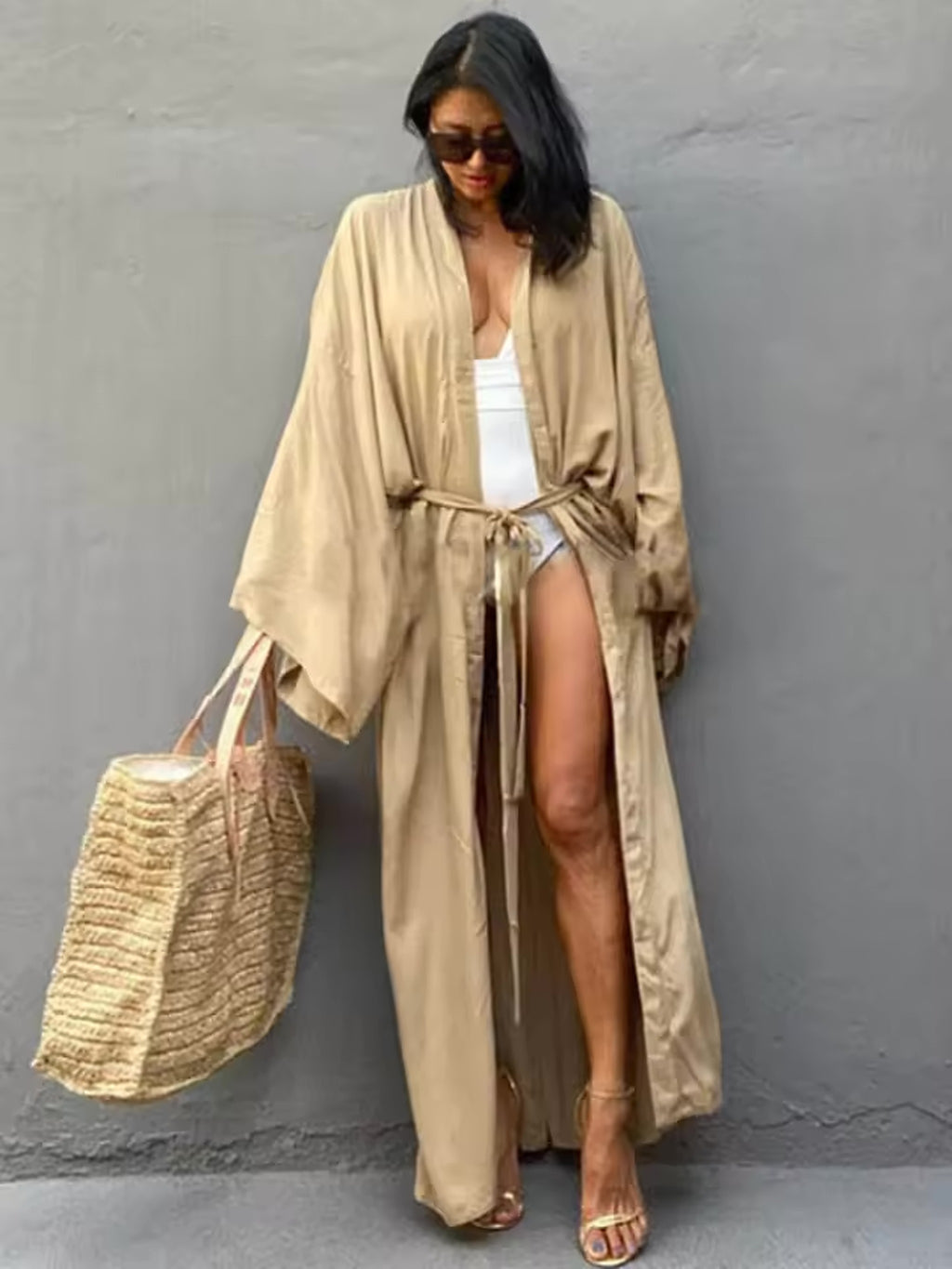 Woman wearing beige Luna Mare cover-up over white swimsuit with sunglasses and straw beach bag